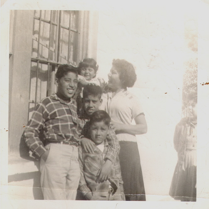 Mario smiling with family. His mom Constancia, his brother Leopoldo and Jose and his sister Teresa (1959)