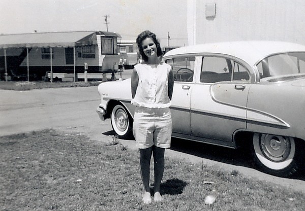 Mary standing next to her car