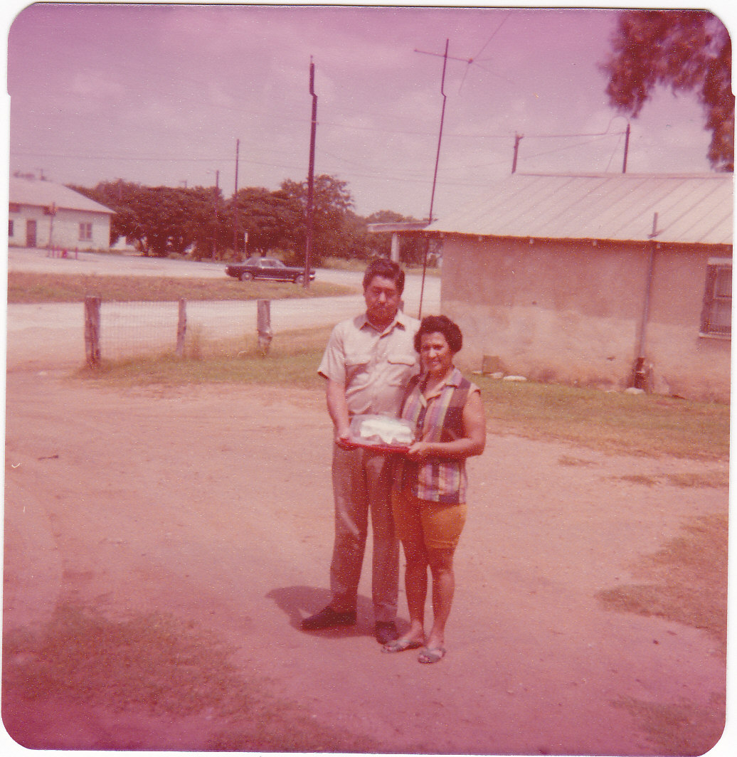 Leo & Consuelo celebrating their 25th wedding anniversary, standing out side their house 1975