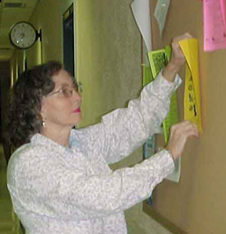 Senior Secretary of Sciences Bonnie Thompson posts a flier in the General Education Biulding. Photo by Michelle Tyler