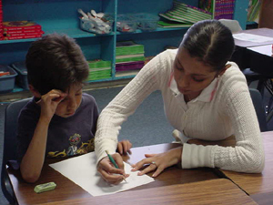 A Palo Alto Elementary student looks on as a Palo Alto College student tutor explains his homework.