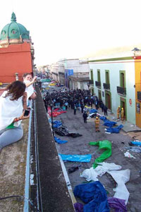 Students snap pictures of the protest from the roof of their hotel in Oaxaca, Mexico. The towels were used to diminish the tear gas' effects.