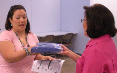 Theresa Molina picks up her graduation gown from Lou Vallejo of Records and Registration.
