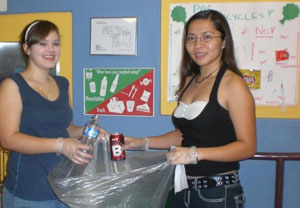SGA Senators Samantha Triana and Tee Nguyen pick up recyclables in the Student Center. SGA's eight senators are volunteers for this Earth-friendly initiative.